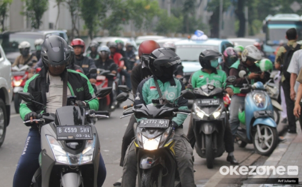 Penumpang memantau rute perjalanan melalui aplikasi transportasi online di ponsel mereka.