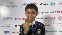 Feri Yudoyono, atlet balap sepeda peraih medali perunggu Asian Games, berpose dengan medalinya.