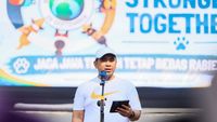 Petugas medis hewan sedang memberikan vaksin rabies kepada anjing peliharaan dalam sebuah program vaksinasi massal. Ilustrasi upaya pencegahan penyakit.
