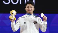 Lifter putra Indonesia, Rahmat Erwin Abdullah, menunjukkan medali emas yang diraihnya di Asian Games 2022 cabang olahraga angkat besi kategori 73 kg putra.