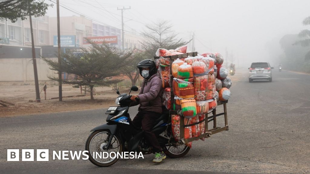 Seorang pengemudi ojek daring berjuang mencari nafkah di tengah kabut asap tebal, menggambarkan tantangan ganda yang dihadapi pekerja informal di wilayah terdampak.