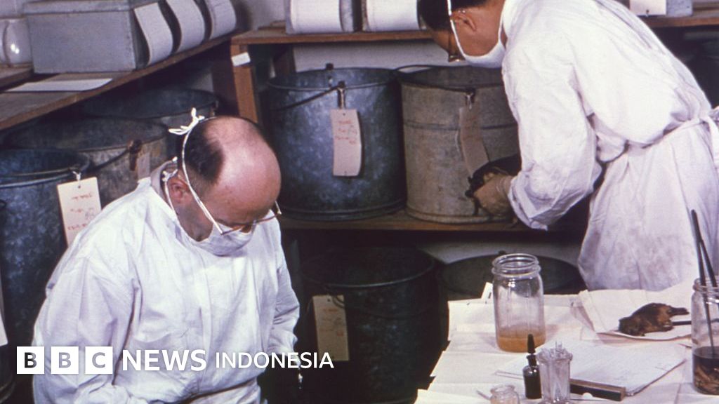 Petugas medis bersiap menghadapi situasi darurat di sebuah fasilitas riset biologis. Kematian misterius seorang ilmuwan di pusat wabah pes Siberia memicu pengawasan ketat ratusan kontak.