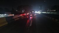 Petugas gabungan membersihkan tumpahan oli di flyover yang menyebabkan sejumlah pengendara motor terjatuh.