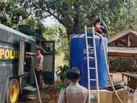 Petugas Kepolisian menyalurkan air bersih kepada warga terdampak kekeringan sebagai bagian dari program 'Polisi Bersama Masyarakat'.