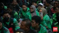 Seorang pengemudi ojek online (ojol) sedang menunggu orderan. Peraturan pemerintah yang membatasi potongan aplikasi sebesar 8 persen diharapkan dapat meningkatkan pendapatan dan memberikan kepastian hukum bagi mereka.